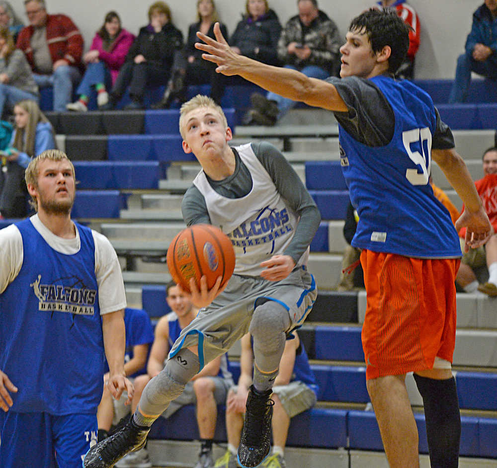 In this December 2014 photo, Thunder Mountain's Chase Saviers scoops a shot under alumni player Ryan Lee. Saviers led the Falcons with 15 points Thursday during the team's opening game against Petersburg on the road.