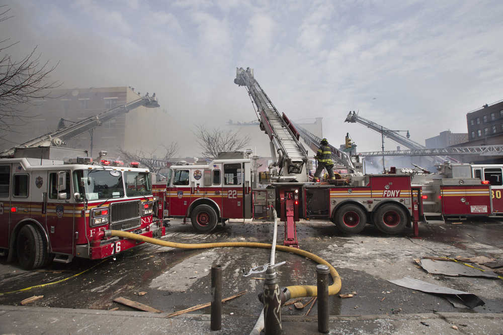 In this March 12, 2014 photo, firefighters respond to a fire after an explosion and building collapse in the East Harlem neighborhood of New York.