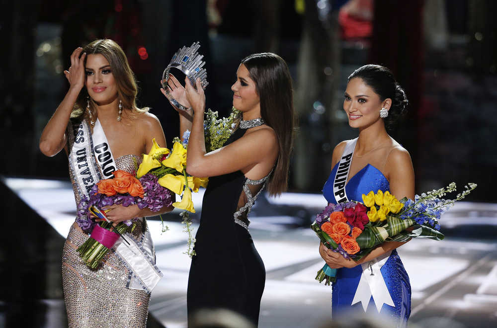 Former Miss Universe Paulina Vega, center, removes the crown from Miss Colombia Ariadna Gutierrez, left, before giving it to Miss Philippines Pia Alonzo Wurtzbach, right, at the Miss Universe pageant on Sunday, Dec. 20, 2015, in Las Vegas. Gutierrez was incorrectly named the winner before Wurtzbach was given the Miss Universe crown. (AP Photo/John Locher)