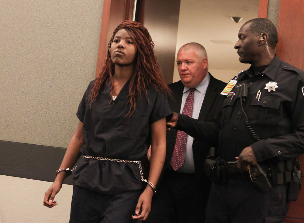 Lakeisha Nicole Holloway enters district court with one of her public defenders, Scott Coffee, for her arraignment Wednesday, Dec. 23, 2015, in Las Vegas. Holloway, who crashed her car into pedestrians on the Las Vegas Strip on Sunday, Dec. 20, has been charged with murder, child abuse and hit-and-run. (AP Photo/Chase Stevens)