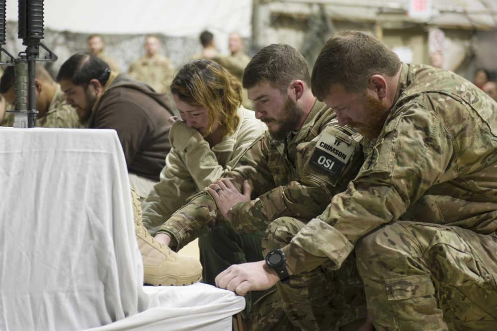 U.S. service members pay their respects during a memorial ceremony for six Airmen killed in a suicide attack, at Bagram Air Field, Afghanistan on Wednesday, Dec. 23, 2015. The deadliest attack in Afghanistan since 2013 killed six U.S. troops on Monday, including a family man from Long Island, New York; a South Texan; a New York City police detective; a Georgia high school and college athlete; an expectant father from Philadelphia; and a major from suburban Minneapolis with ties to the military's LGBT community. They were killed when their patrol was attacked by a suicide bomber on a motorcycle near Bagram Air Base, the Defense Department said. (Tech. Sgt. Robert Cloys/U.S. Air Force via AP)