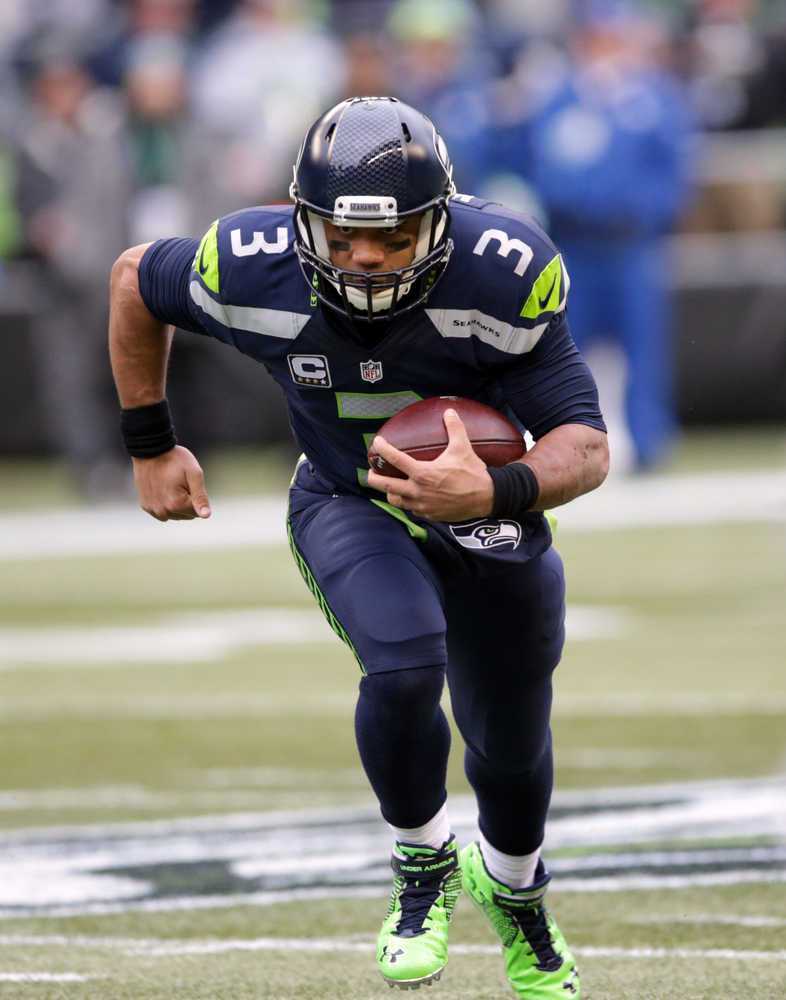 Seattle Seahawks quarterback Russell Wilson runs with the ball against the Cleveland Browns in the first half of an NFL football game, Sunday, Dec. 20, 2015, in Seattle. (AP Photo/Scott Eklund)