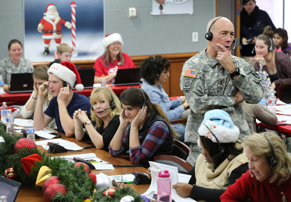 In this Dec. 24, 2014, file photo, NORAD and U.S. Northern Command (USNORTHCOM) Chief of Staff Maj. Gen. Charles D. Luckey joins other volunteers taking phone calls from children around the world asking where Santa is and when he will deliver presents to their homes, inside a phone-in center during the annual NORAD Tracks Santa Operation, at the North American Aerospace Defense Command, at Peterson Air Force Base, Colo. Hundreds of military and civilian volunteers at NORAD are estimated to field more than 100,000 calls this year through Christmas Eve, from children from all over the world eager to hear about Santa's progress.