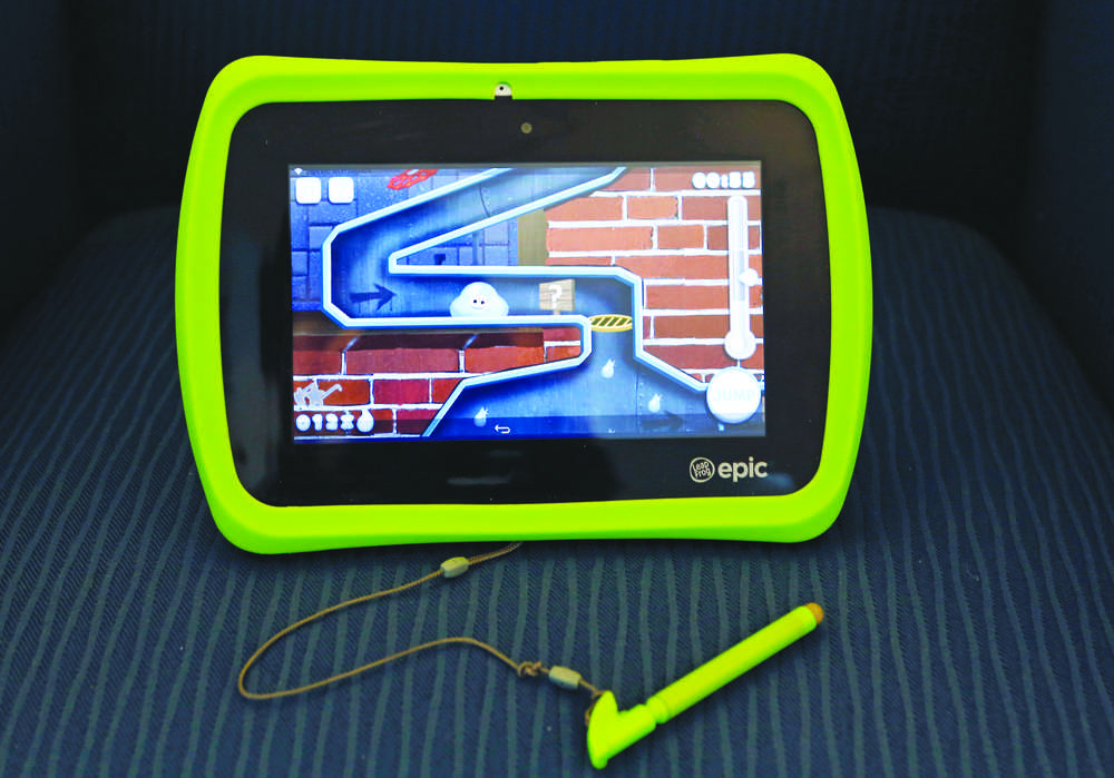 LeapFrog's Android-based Epic kids tablet is shown Monday, Dec. 21, 2015, in New York. As competition has increased, kids' tablets have come a long way from bad graphics, slow processors, chunky exteriors and child-like operating systems. The Epic has a sleek design, but the bright green bumper is removable. It's much faster than a LeapPad and can run Android-based content, but in-app purchases and inappropriate ads are blocked. (AP Photo/Kathy Willens)
