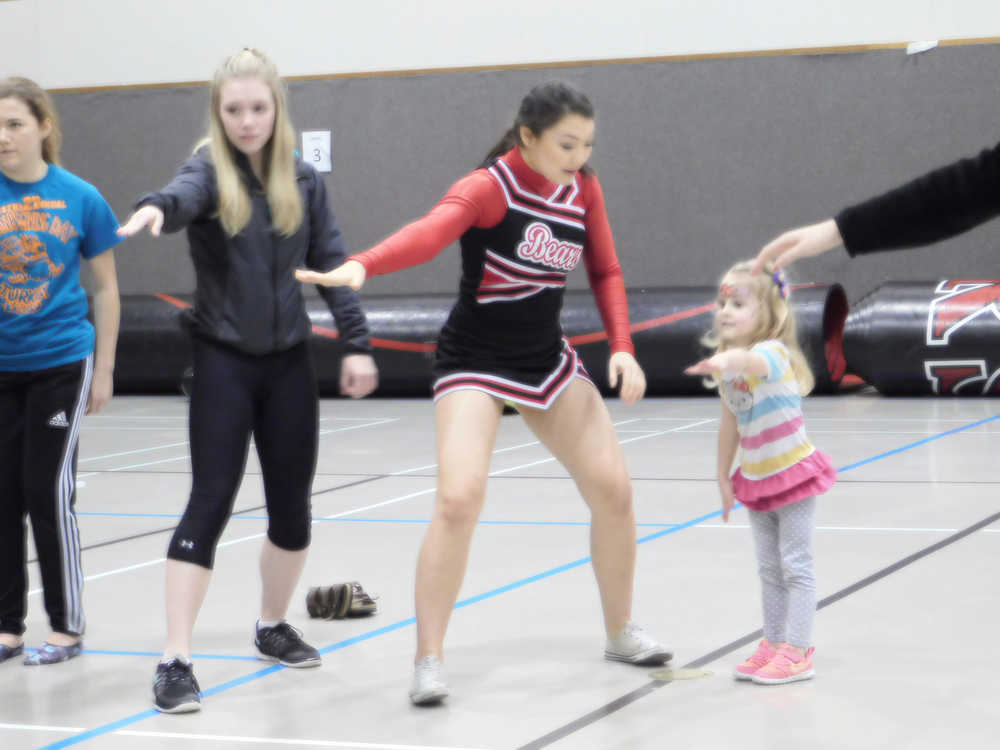 Members of the JDHS Basketball Cheer team do the Hokey Pokey with a young guest during the team's "Parents Night Out" fundraiser Dec. 23.