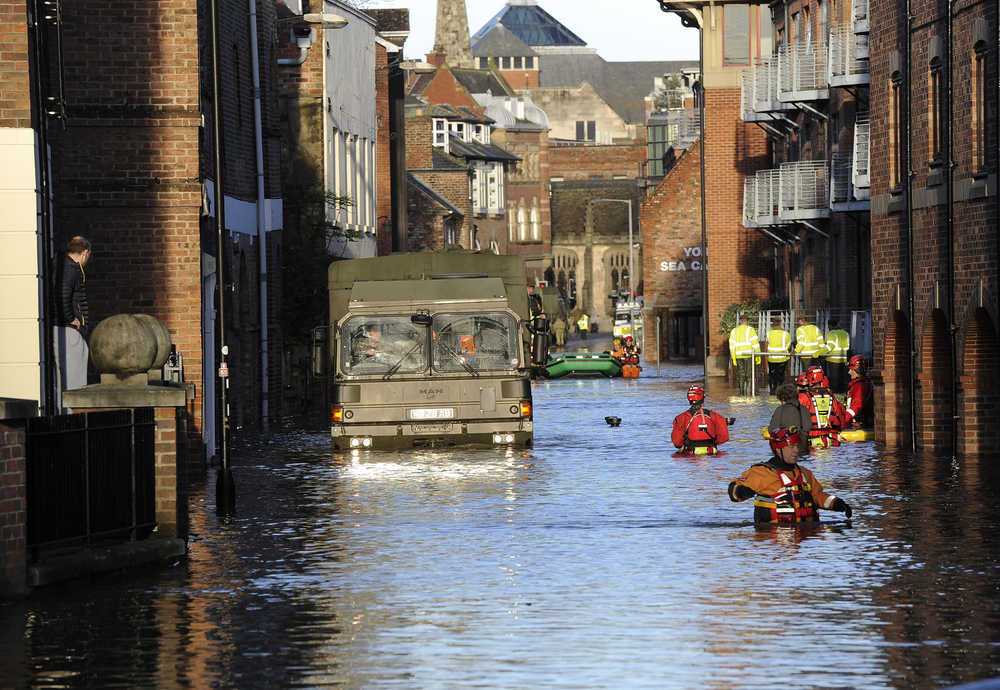 Members of the Army and rescue teams wade through floodwater in York city center after the River Ouse and the River Foss burst their banks on Sunday.