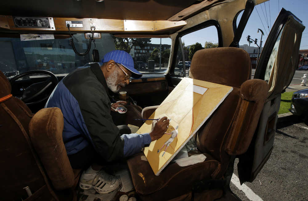 In this Nov. 10 photo, Ira Watkins, a homeless artist, works on a painting inside of the van where he works and lives in the Bayview-Hunters Point district in San Francisco.