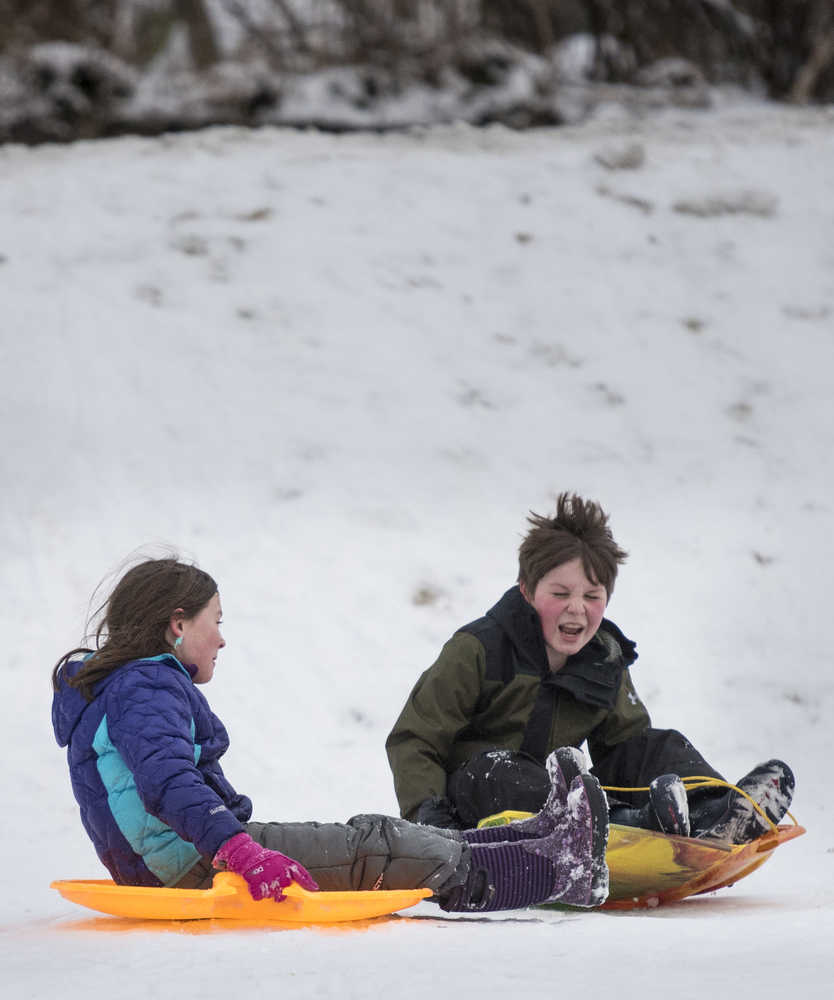 Zayden Schijven, 11, right, sleds with Lena Field, 8, above the Evergreen Cemetary on Monday.
