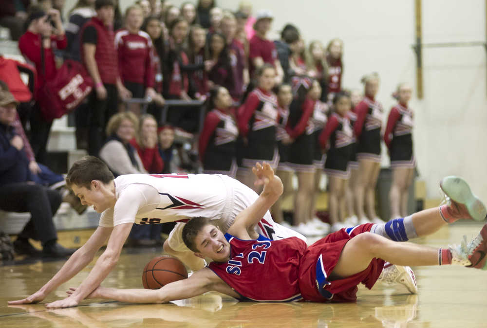 Juneau-Douglas' Kaleb Tompkins tumbles over Sitka's Tevin Bayne as they chase a loose ball during the Princess Cruises Alaska Airlines Capital City Classic at JDHS on Tuesday. Juneau won 81-63.