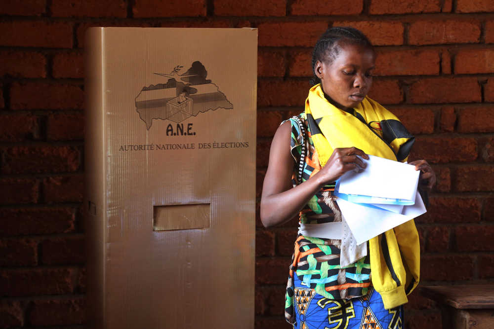 A woman folds her ballots before casting her vote during elections in Bangui, Central African Republic, Wednesday.
