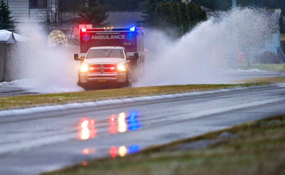A Capital City Fire/Rescue ambulance splashes through a flooding area of Riverside Drive on their way to a call on Jan. 1.