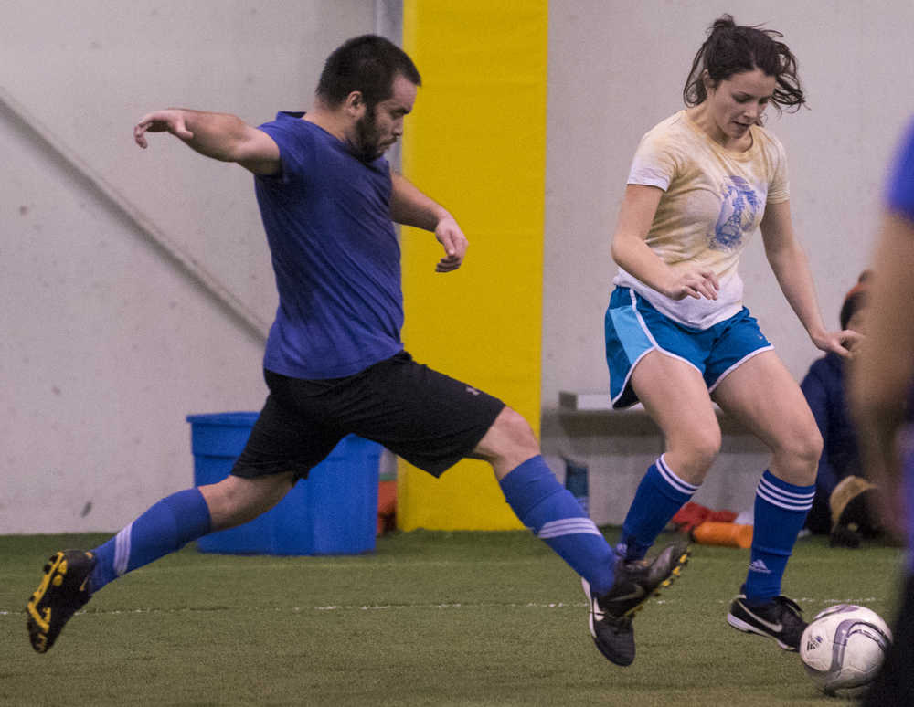 Honey Badgers' Stefan Ashe, left, lunges for the ball posessed by Las Mamacitas y Los Yung Sahns' Monica Daugherty, right, during their masters division game in the Holiday Cup at the Dimond Park Fieldhouse on Wednesday. Las Mamacitas y Los Yung Sahns defeated the Honey Badgers 8-0.