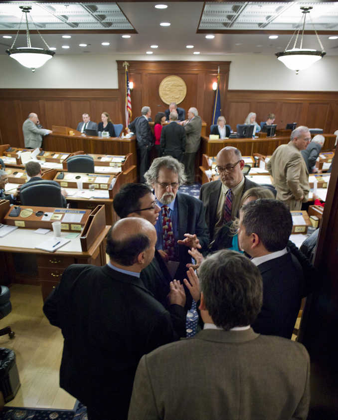 House Minority members cluster to talk as the House debates the state's operating budget at the Capitol on April 27, 2015.