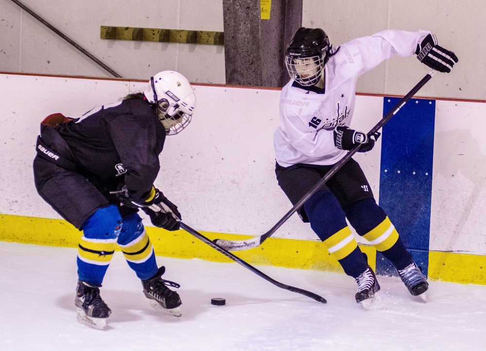 Kaylee Lanhum, left, covers Jaime Hort during a makeshift game during JDIA's all-girls hockey session at Treadwell Arena.