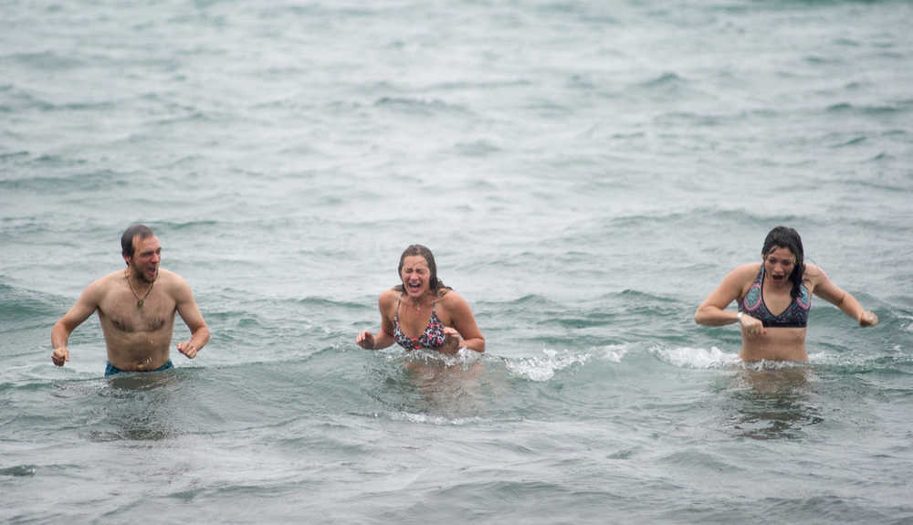 Matt Kern, Lia Heifetz, center, and Katey Blagden react to the cold water during the 24th annual Polar Bear Dip at the Auke Village Recreation Area on Friday, Jan. 1, 2016.
