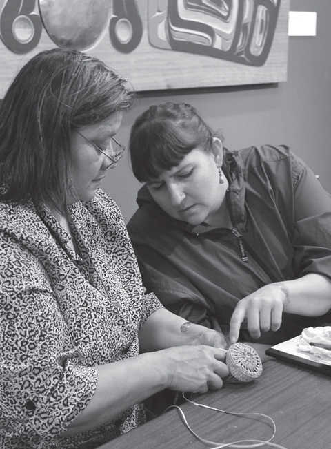 Instructor Holly Churchill assists Brooke Johnson during a Totem Heritage Center class in 2014.