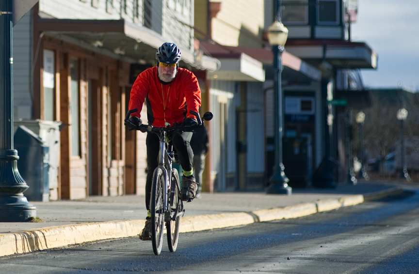 Paul DeSloover rides his bicycle around Juneau in sunny weather, February 2015.