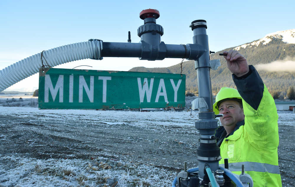 Eric Vance, manager of Juneau's Capitol Disposal Landfill, examines the vacuum on a methane well on Tuesday, Jan. 5, 2016. The well, one of 30 pumping gas with a distinct sulphur smell, was ironically decorated by an employee with a Mint Way sign.