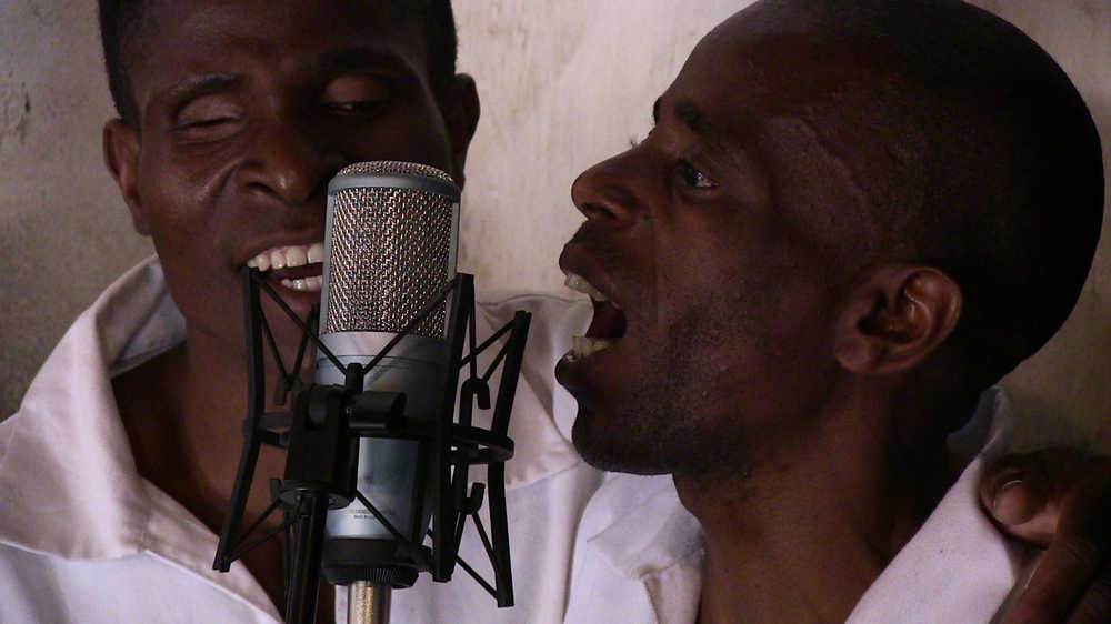 In this photo taken August 24, 2014, members of the Zomba Prison group record songs at the Zomba Prison in southern Malawi. The gentle chorus of maximum security prisoners singing over guitar chords has earned Malawi its first Grammy nomination making history in the impoverished African nation.