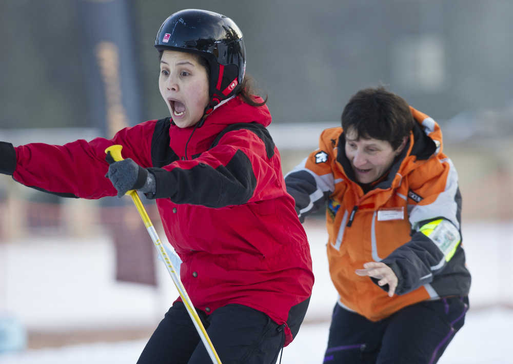 Jeorghette Plang, left, reacts to ski instructor Leslie Antolick's helpful push during the the World's Largest Lesson at Eaglecrest on Friday as part of Learn to Ski and Snowboard Month. The event, that included 80 participants and 17 instructors, was part of a national attempt to break a Guinness World Record.