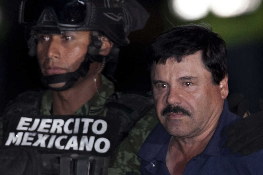 Mexican drug lord Joaquin "El Chapo" Guzman, right, is escorted by soldiers and marines to a waiting helicopter, at a federal hangar in Mexico City, Friday, Jan. 8, 2016. The world's most wanted drug lord was recaptured by Mexican marines Friday, six months after he fled through a tunnel from a maximum security prison in an escape that deeply embarrassed the government and strained ties with the United States.(AP Photo/Marco Ugarte)