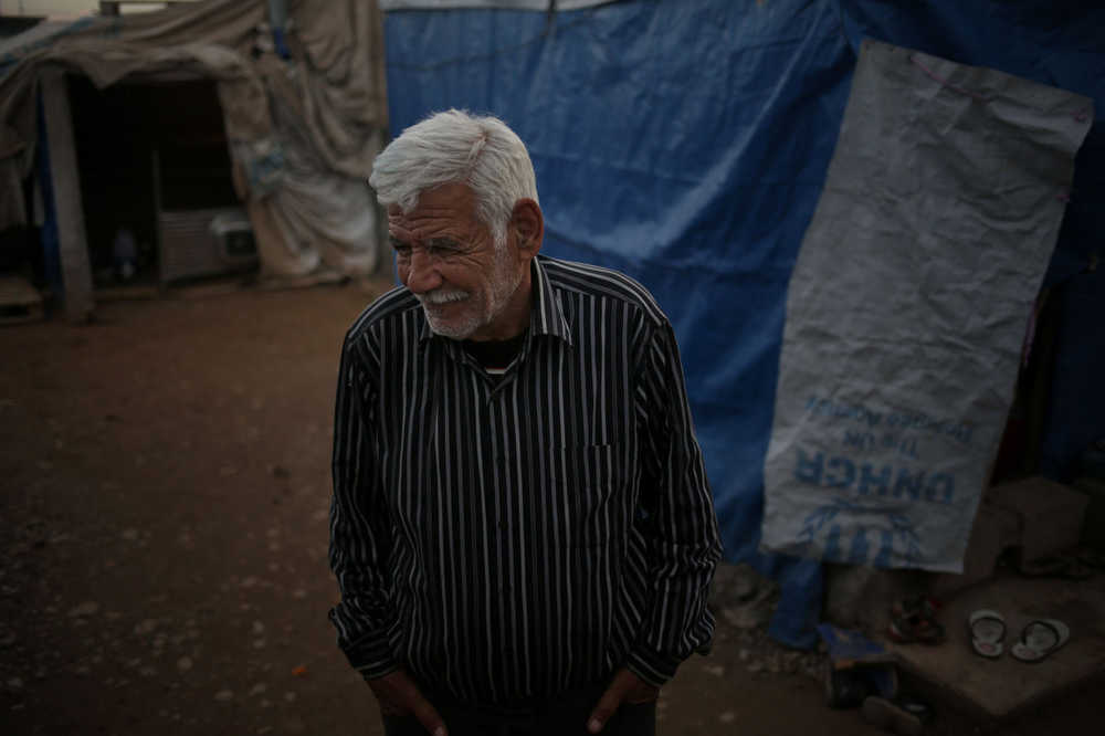 This  Monday, Jan. 11, 2016 photo shows  Ibrahim Mahmoud standing in Baharka refugee camp in Iraq's northern Kurdish region. At the age of 9, during the 1948 Israeli-Arab war he fled his native Haifa with his family to Iraq and he hasn't left ever since. The now 76 year-old never got rid of the refugee status. The last city he lived in was Mosul, until it got taken by the Islamic State group. Ibrahim and his family fled again, this time to the Northern Kurdish region of Iraq. (AP Photo/Bram Janssen)