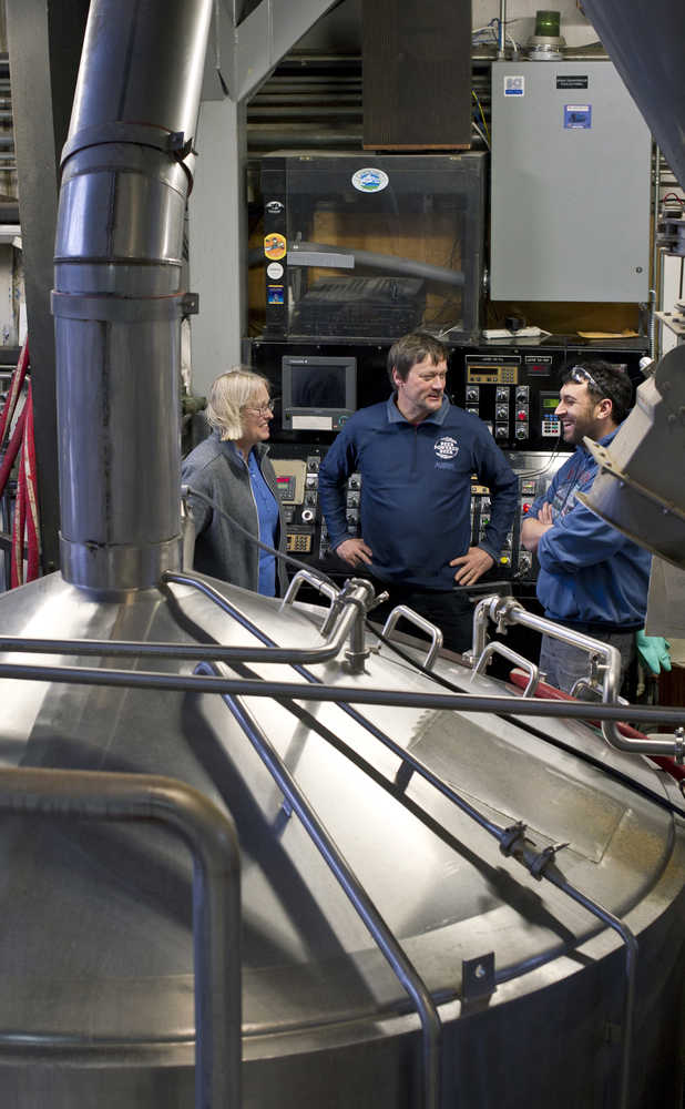 Marcy and Geoff Larson, founders of the Alaskan Brewing Company, speak with brewer Chaz Lakit, right, on the company's brew deck on Thursday.