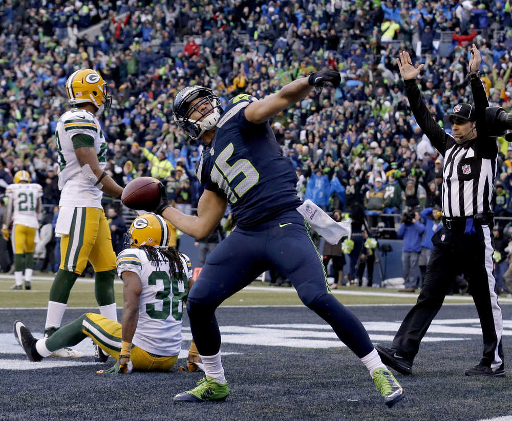 In this Jan. 18, 2015 photo, Seattle Seahawks wide receiver Jermaine Kearse throws the ball into the stands after scoring the game-winning touchdown against the Green Bay Packers during overtime of the NFC championship game in Seattle. The Packers also lost in overtime in the playoffs this year, never getting a possession in overtime in either game.