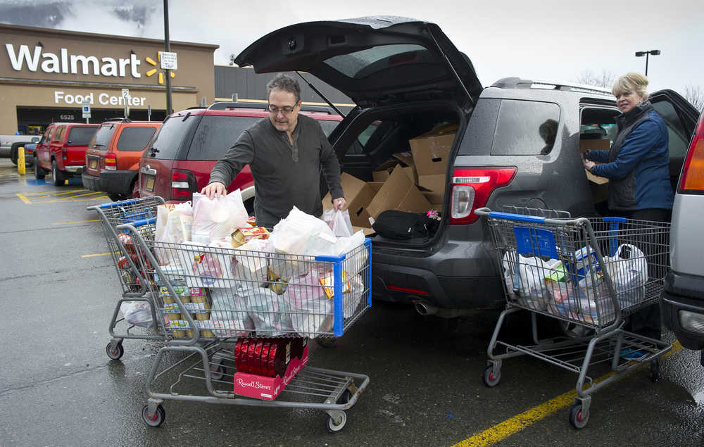 Ed and Barbara Phillips of the Icy Strait Lodge in Hoonah pack their vehicle after taking advantage of the store-closing sales at Walmart on Friday.