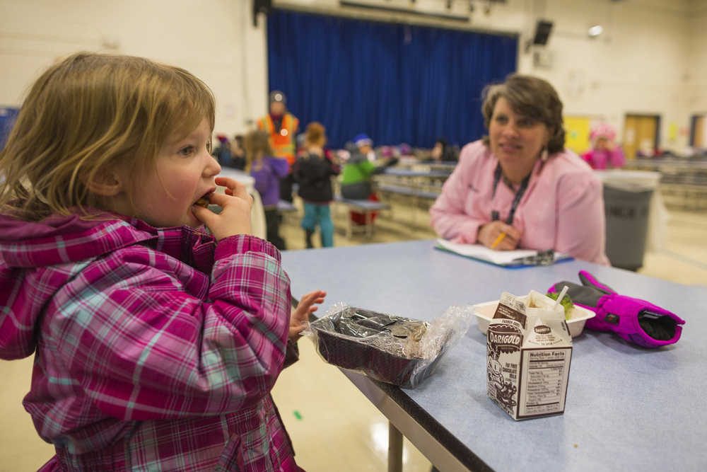 In this photo taken Jan. 14, Anchorage School District central kitchen manager and chef Karen Richardson watches as Sophie Novakovitch, 5, tries a new menu item - maple sweet potato cubes - at Huffman Elementary school in Anchorage.