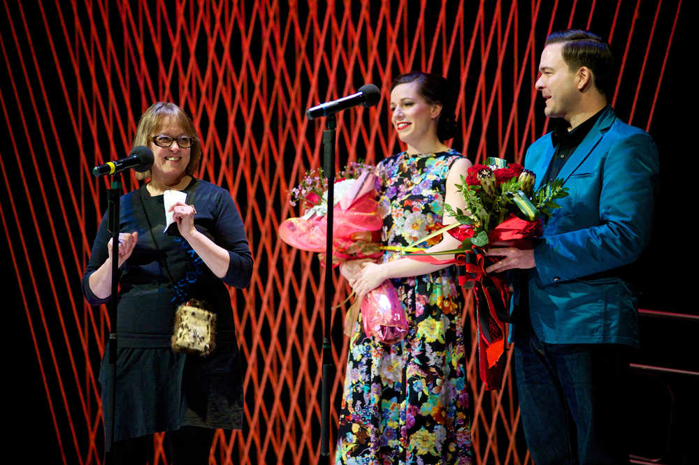 JAHC Executive Director Nancy DeCherney acknowledges emcees Allison Holtkamp and Scott Burton at the halfway point of the Wearable Art Show sponsored by the Juneau Arts & Humanities Council at Cenntenial Hall in Feb. 2015.
