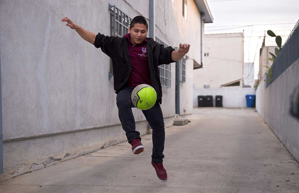 Marvin Velasco, 15, practices soccer outside his new home in Los Angeles on Monday, Jan. 11, 2016. Velasco's perilous journey from Guatemala included crossing a river, even though he doesn't swim, and getting lost at night in a frigid desert. Once in the United States, he turned himself in to U.S. Border Patrol agents in Reynosa, Texas, and was sent to a shelter run by the U.S. Department of Health and Human Services' Office of Refugee Resettlement. (AP Photo/Mark J. Terrill)