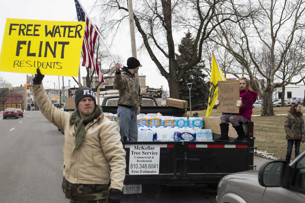 Genesee County Volunteer Militia members and protesters gather for a rally outside of Flint City Hall on Sunday Jan. 24, 2016, over the city's ongoing water crisis. The militia was handing out free bottled water and water filters. (Conor Ralph/The Flint Journal - MLive.com via AP)