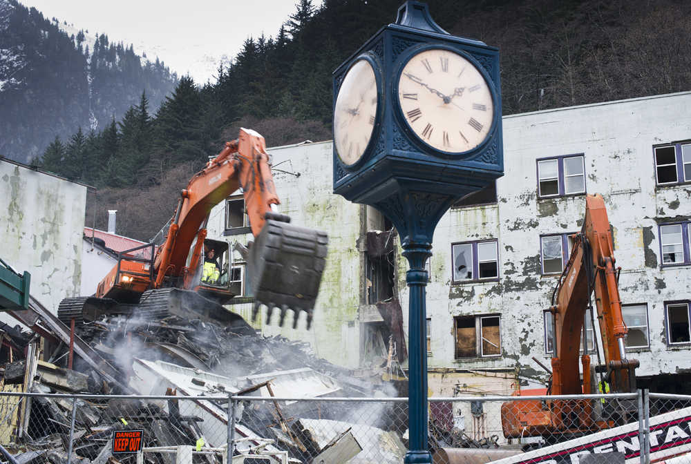 Mitch McGraw uses an excavator to topple the Gastineau Apartments walls facing Franklin Street on Wednesday. See a video of the demolition at juneauempire.com.