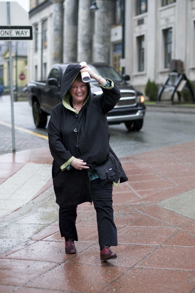 Shelly Wright holds her coat during a blast of wind and rain downtown on Thursday. The National Weather Service forecast for Friday calls for numerous rain showers, highs around 39. Southeast wind 10 mph.
