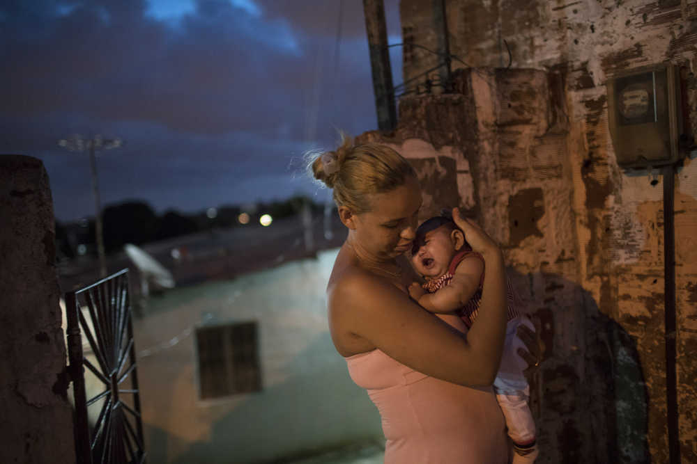 Gleyse Kelly da Silva, 27, holds her daughter Maria Giovanna, who was born with microcephaly, outside their house in Recife, Pernambuco state, Brazil, Wednesday, Jan. 27, 2016. Brazilian officials still say they believe there's a sharp increase in cases of microcephaly and strongly suspect the Zika virus, which first appeared in the country last year, is to blame. The concern is strong enough that the U.S. Centers for Disease Control and Prevention this month warned pregnant women to reconsider visits to areas where Zika is present. (AP Photo/Felipe Dana)