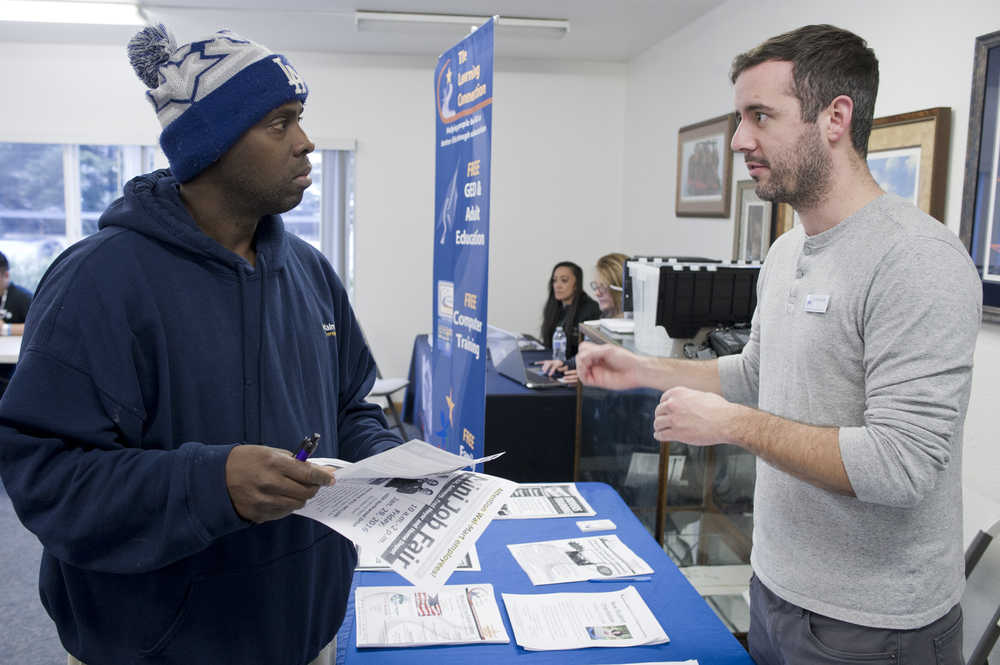 Donald Stokes, a loading dock supervisor for Walmart, left, listens to Jeff Smith, the Southeast Regional Adult Basic Education Coordinator for The Learning Connection, during a special job fair for Walmart employees held at Gruening Park on Friday. Juneau's Walmart is slated to close Feb. 4.