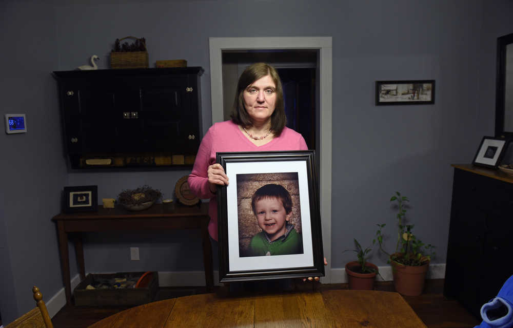 ADVANCE FOR USE SATURDAY, FEB. 6, 2016 AT 8 A.M. EST AND THEREAFTER; THIS STORY MAY NOT BE PUBLISHED, BROADCAST OR POSTED ONLINE BEFORE SATURDAY, FEB. 6, 2016 AT 8 A.M. EST - Hollie Ayers poses with a photograph of her late son, Michael, 2, at her home in Bedford, Pa., on Monday, Jan. 18, 2016. Michael, was shot and killed in front of her by her abusive ex-husband in 2013. Ayers was shot in the face and the leg, and her ex-husband killed himself after the rampage. More than a dozen states over the past two years have strengthened laws meant to keep firearms out of the hands of domestic abusers, a rare area of consensus in the nation's highly polarized debate over guns. (AP Photo/ John Beale)