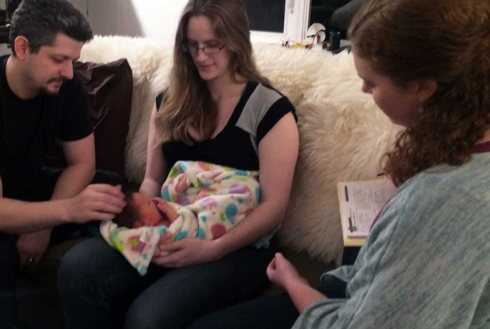 Madi Nolan-Grimes, clinical director of The Juneau Family Health and Birth Center, speaks to parents Lynn and Chad Burnett during an in-home visit with their newborn, Johannes Ulyess Burnett, last month.