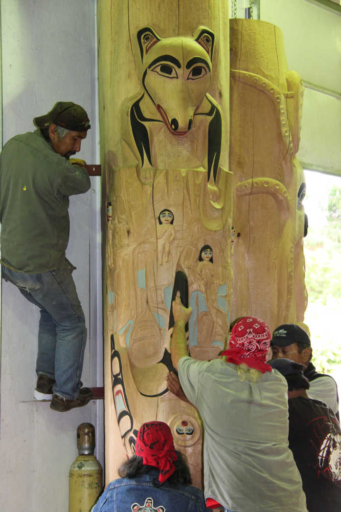 The Kaagwaantaan House post is raised for display at  Xúna Shuká Hit (Glacier Bay Tribal House). At left is carver Owen James.
