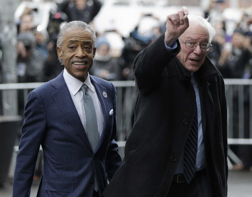 Democratic presidential candidate Sen. Bernie Sanders, I-Vt., right, raises a fist as he arrives for a breakfast meeting with Al Sharpton at Sylvia's Restaurant, Wednesday, Feb. 10, 2016, in the Harlem neighborhood of New York. Sanders defeated former Secretary of State Hillary Clinton on Tuesday in the New Hampshire primary. (AP Photo/Seth Wenig)