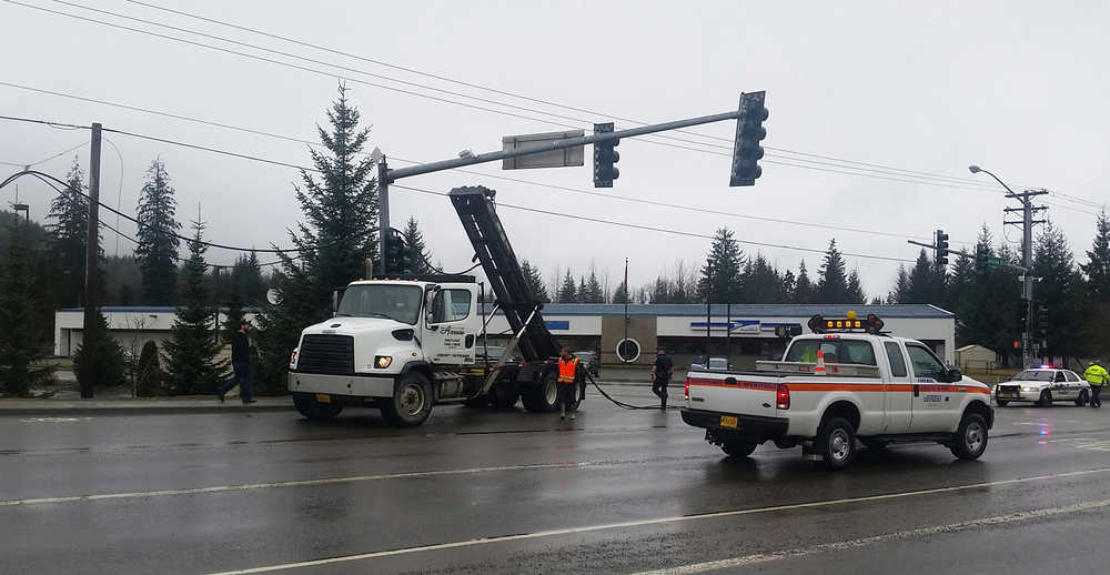 A telephone wire for 700 Juneau phone lines is sprawled across the left turn lane on Vintage Drive Wednesday after an Arrow Refuse truck's garbage lift hooked on the line, bringing it down and traffic to a stop.