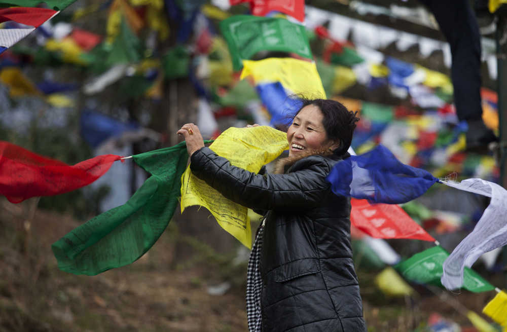 An exile Tibetan holds multi color prayer flags called wind horse or 'lungta' to be tied on tall posts on the third day of the Tibetan New Year on Thursday in Dharmsala, India. Tibetans believe that the Buddhist prayers printed on these flags whose colors represent the five elements, earth, fire, sky, water and air, are spread on wind.