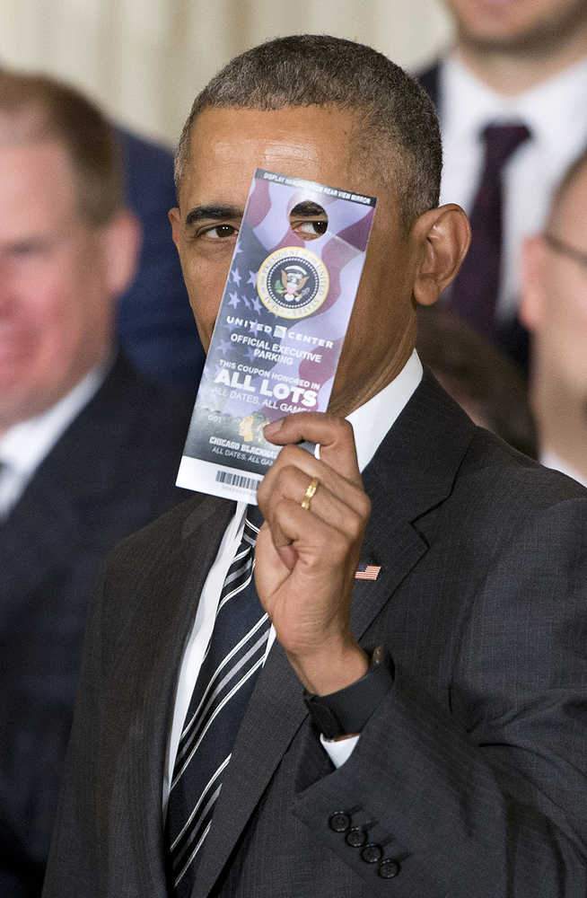 President Barack Obama holds up a parking pass that was presented to him by Chicago Blackhawks Chairman Rocky Wirtz on Thursday in the East Room of the White House. The lifetime parking pass is good for all games and all dates at the United Center in Chicago.