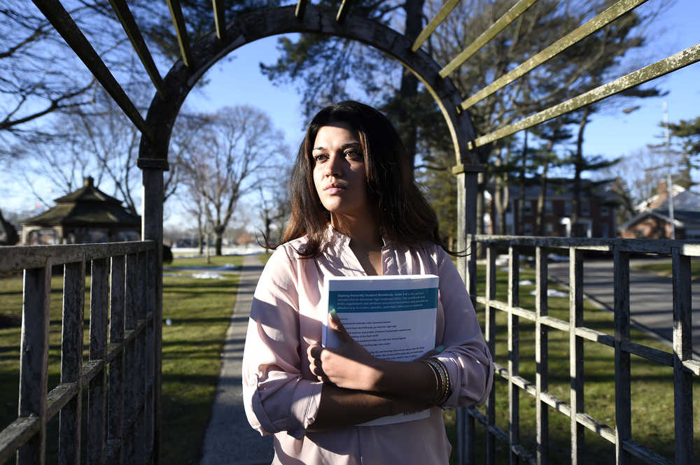 In this Feb. 2, 2016 photo, Naila Amin, 26, holds a book from one of the classes she is taking at Nassau Community College in Garden City, N.Y. Amin, who was forced into marriage at the age of 15 to a 28-year-old cousin in Pakistan who beat and mistreated her, aspires to become a social worker and open a group home for girls trying to avoid or recover from forced marriages. (AP Photo/Kathy Kmonicek)