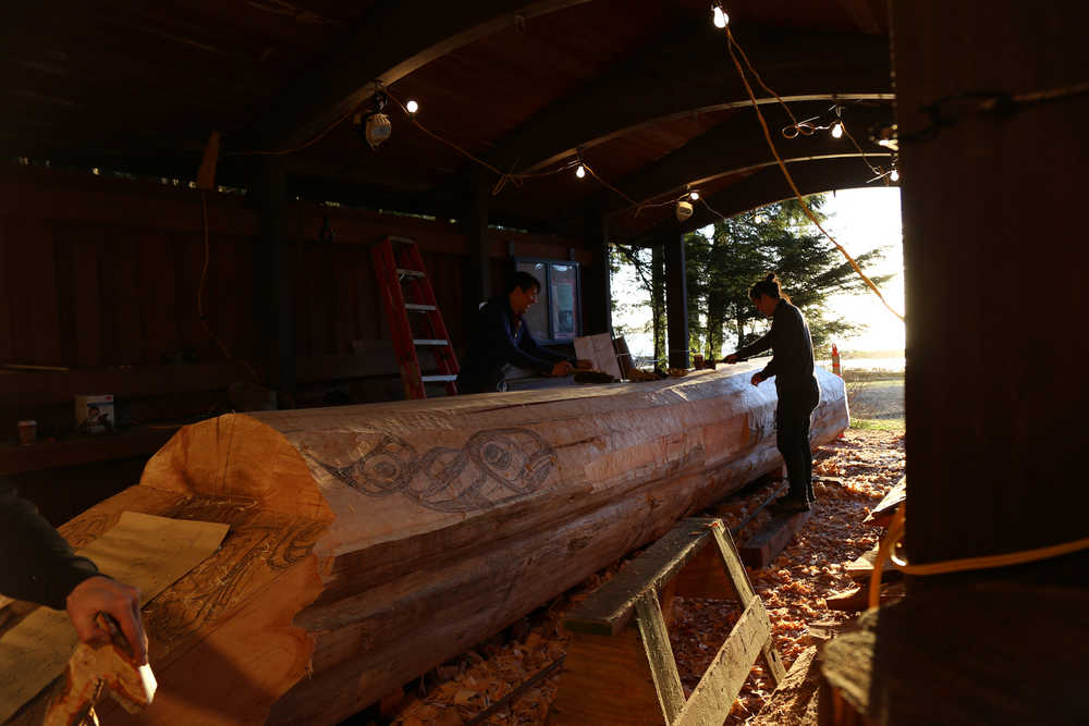 Jerrod Galanin and TJ Young work on the canoe. (National Park Service | Erin Fulton)
