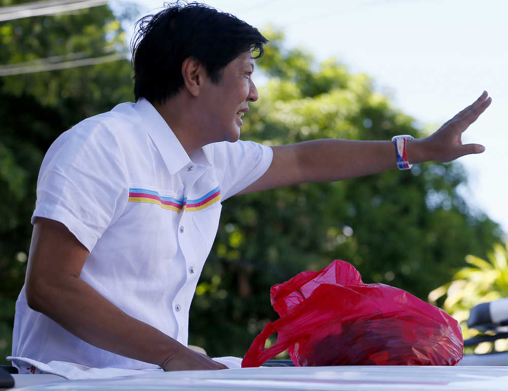 In this Feb. 22 photo, vice-presidential candidate Sen. Ferdinand "Bongbong" Marcos Jr. waves to supporters during his campaign sortie in Muntinlupa city, southeast of Manila, Philippines.