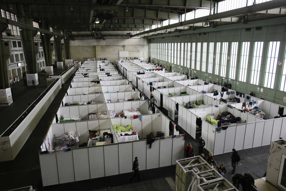 FILE - In this Wednesday, Dec. 9, 2015 file photo, cabins are set up inside Hanger 4 of the former airport Tempelhof to be used as a temporary emergency shelter for migrants, refugees and asylum seekers in Berlin. Across Europe, gay, lesbian and transgender migrants say they suffer from verbal, physical and sexual abuse in refugee shelters, and some have been forced to move out. The AP found out about scores of documented cases in The Netherlands, Germany, Spain, Denmark, Sweden and Finland, with the abuse usually coming from fellow refugees and sometimes security staff and translators. In Germany, the Lesbian and Gay Federation counted 106 cases of violence against homosexual and transgender refugees in the Berlin region from August through the end of January 2016. Most of the cases came from refugee centers, and 13 included sexual abuse. (AP Photo/Markus Schreiber, file)
