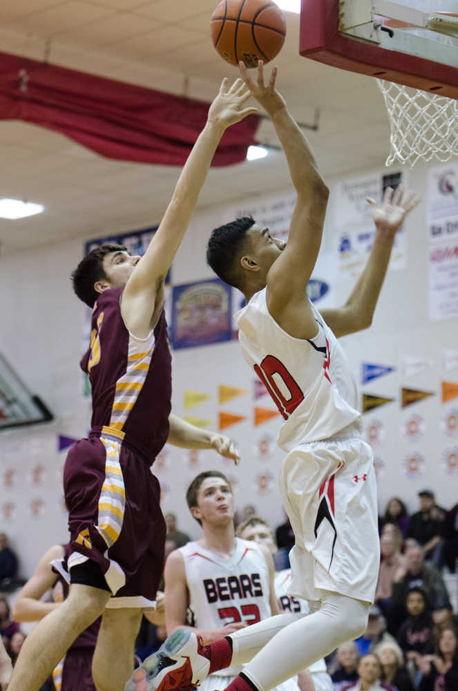 Juneau-Douglas's Molo Maka lays it up against Ketchikan's Jake Smith during their game Friday night at JDHS. Juneau won 72-64.
