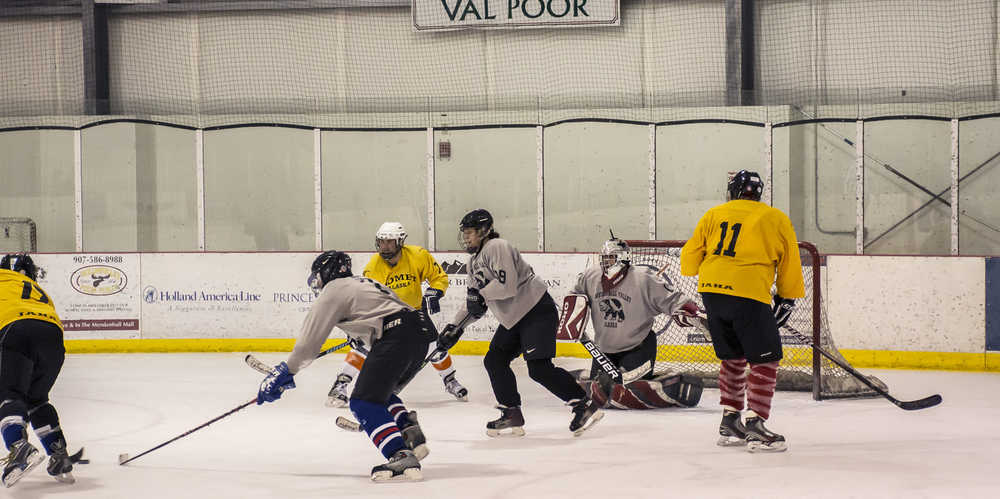 The Comets' Brett Doutt attempts a backhand shot against Mendenhall Valley's goalie Ken Arnold. Defenseman Spike Bicknell and Myiia Whato lend defensive support while Jayme Johns and Tom Straugh (11) look for opportunities to score. The Comets won 4-1 on two goals by Jim Robinson. In earlier action, the Huskies defeated White Pass 1-0.